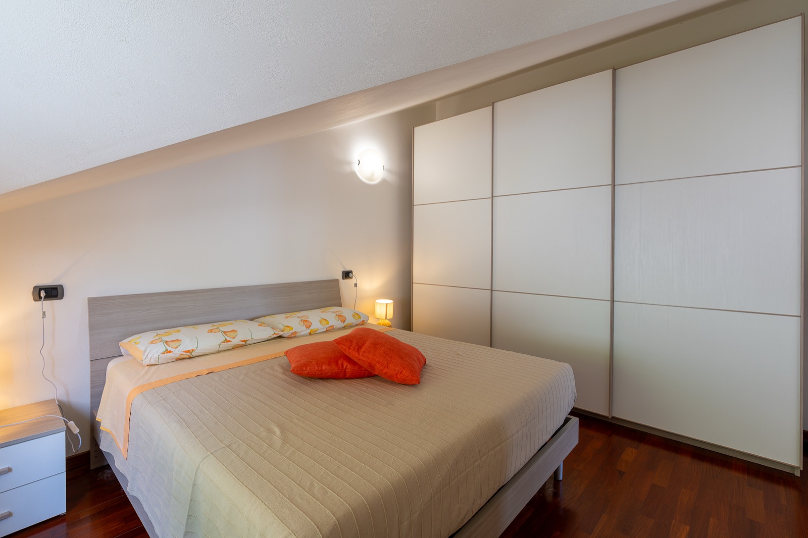 Letto matrimoniale con cuscini arancioni
