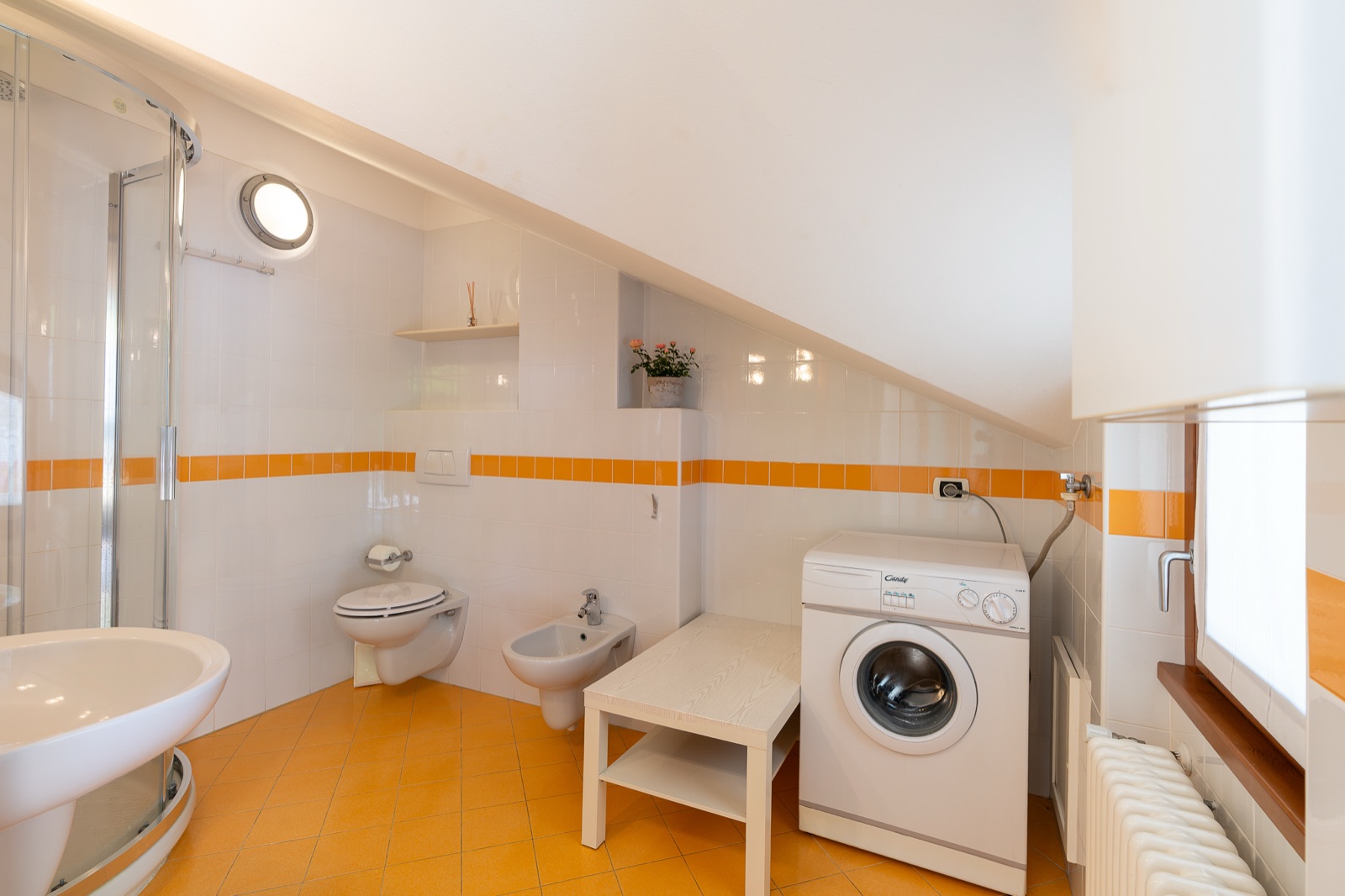 Bagno con doccia, sanitari e lavatrice